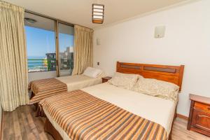 伊基克阿波罗卡弯查公寓的酒店客房设有两张床和一个阳台。