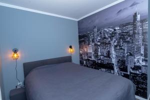 卢卡维卡Athena Apartman的卧室配有一张床铺,墙上挂着黑白照片