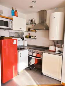 比韦罗Beachport的厨房配有白色橱柜和红色冰箱