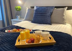 弗林特The North Wales Gathering - 9 Bedroom - EV Charging的床上的食品托盘,包括饮料和小吃