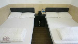 香港九龙旺角1812宾馆的两张睡床彼此相邻,位于一个房间里