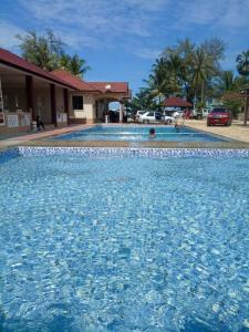 巴西富地Faris's Homestay & Resort的一座房子前面的蓝色海水游泳池