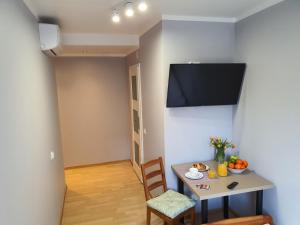 华沙Jasna Hotelik的一间设有桌子和墙上电视的用餐室