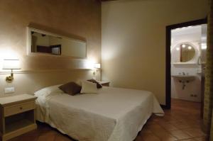 托斯科拉诺-马德尔诺Albergo CAVALLINO 10的一间卧室配有床、镜子和水槽