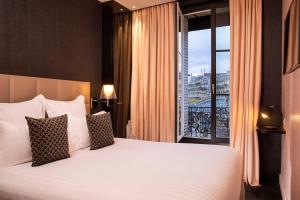 巴黎巴黎艾菲尔铁塔之旅第一酒店的一间卧室设有一张大床和一个大窗户