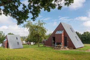 比特亨巴赫Zentrum Worriken Holiday Cottages的一座谷仓,由金属屋顶和红砖房子改建而成