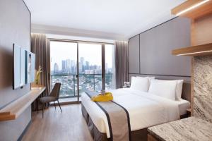 雅加达Somerset Sudirman Jakarta的酒店客房设有一张床和一个大窗户