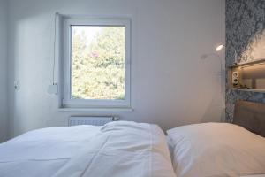 StahlbrodeFerienhaus Rügenblick的窗户客房内的一张白色床
