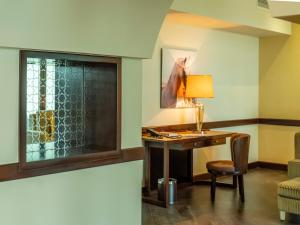 多哈Retaj Salwa Resort & Spa的客房配有带台灯和椅子的书桌