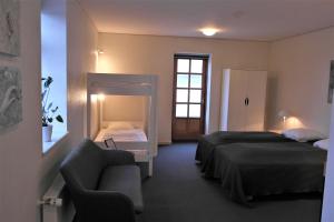 沃柏斯斯科亚德贝格伽尼酒店的一间卧室配有两张床、一张沙发和一把椅子