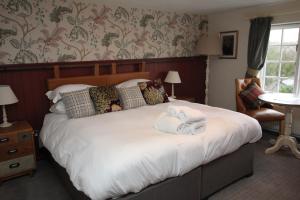伍尔乡下人旅馆的一间卧室配有一张大床和毛巾