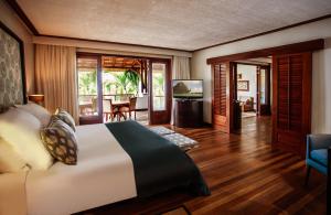 勒莫尔尼Paradis Beachcomber Golf Resort & Spa的一间卧室设有一张床和一间客厅。