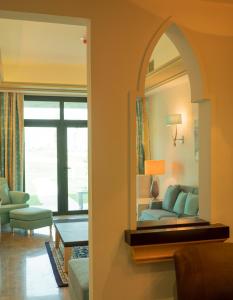 多哈Retaj Salwa Resort & Spa的客厅配有镜子和沙发