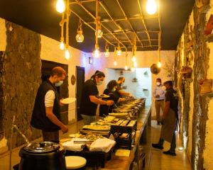 Dār Sawdāʼ萨马高地度假村的一群站在厨房准备食物的人