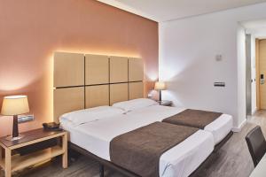 瓦伦西亚西尔肯瓦伦西亚之门酒店的卧室配有一张白色大床和一张书桌