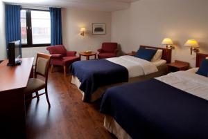 阿沃斯塔尼亚明星贝斯特韦斯特酒店的酒店客房带两张床、一张桌子和椅子。