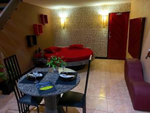 福塔莱萨Motel Emoções (Adults Only)的客厅配有桌子和床。
