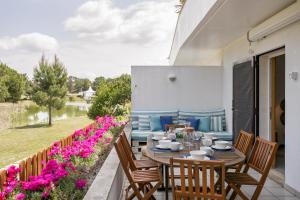 特罗亚Casa de Férias - Troia Terrace Lake & Pool - Soltroia Comporta Aluguer的庭院配有桌椅和鲜花