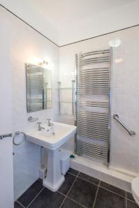 奥尔德堡Beach House - Aldeburgh Coastal Cottages的白色的浴室设有水槽和淋浴。