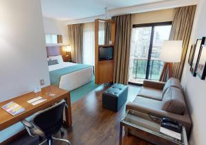 圣保罗伊斯坦广场波里尼酒店的酒店客房配有一张床、一张沙发和一张书桌。