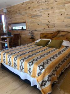 CholilaWau Purul, Cabaña 2的一间卧室设有一张带木墙的大床