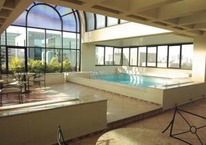 圣保罗伊斯坦广场纳克斯犹达斯酒店的一座大型游泳池,位于一座带窗户的建筑内
