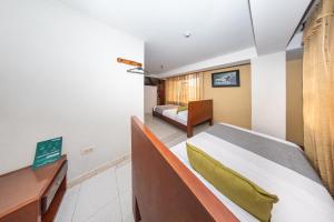 波哥大Hotel Ayenda Bioma 1010的一间卧室配有一张床、一张桌子和一张沙发