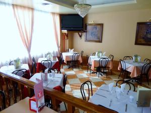 瓜达拉哈拉坎维克酒店的一间带桌椅和电视的用餐室