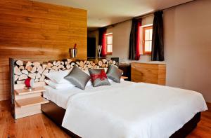卡姆尼克Penzion Repnik的卧室设有白色大床和木墙