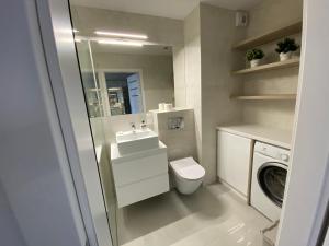 波兹南Flat4You II的浴室配有卫生间、盥洗盆和洗衣机。