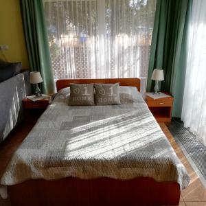 迈泽克韦什德Bokreta Udulohaz的一间卧室设有床铺和一个带绿色窗帘的窗户。