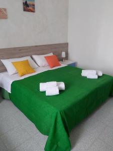 圣多米尼卡Case Costa Degli Dei的一张绿色大床,上面有毛巾