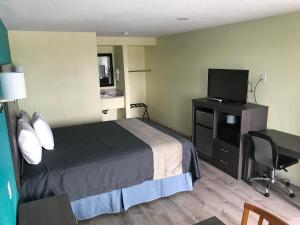 Gila BendGila Bend Lodge的酒店客房配有一张床和一张书桌及一台电视