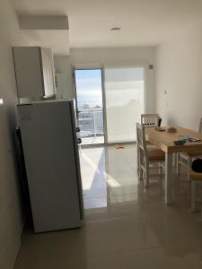 玛德琳港Departamento Centrico VDL的厨房配有冰箱和桌椅