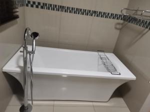 波罗瓜尼Erins Haven - Polokwane的带淋浴的浴室配有白色浴缸。
