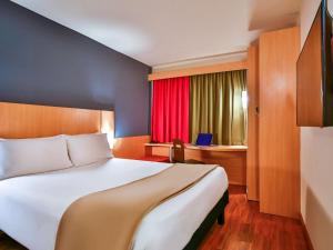 里约热内卢里约博塔弗戈宜必思酒店的酒店客房设有一张大床和一个红色窗户。