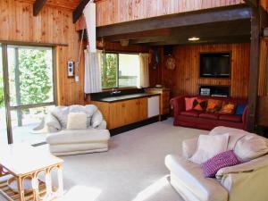 Okere FallsLakeside Villa - Lake Rotoiti Holiday Home的一间带两张沙发的客厅和一间厨房