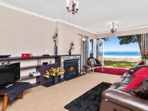RotokawaLake Shores Cottage - Hannahs Bay Holiday Home的一间带壁炉的客厅,享有海景