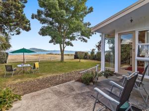 RotokawaLake Shores Cottage - Hannahs Bay Holiday Home的房屋设有带桌椅的庭院