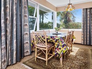 RotokawaLake Shores Cottage - Hannahs Bay Holiday Home的一间带桌椅和窗户的用餐室