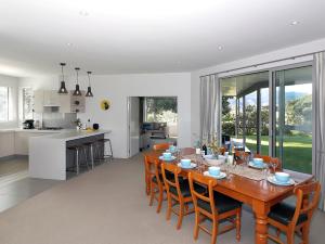布伦海姆Marlborough Magic - Rapaura Holiday Home的用餐室以及带木桌和椅子的厨房