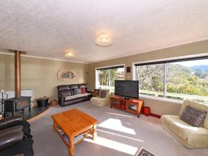 哈夫洛克Mahakipawa Hideaway - Marlborough Sounds Home的带沙发、电视和桌子的客厅