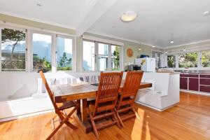 帕拉帕拉乌姆海滩Beach House - Paraparaumu Beach Holiday Home的厨房配有木桌和椅子