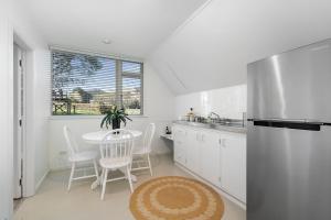 Te HoroThe Apartment - The Lodge Te Horo的厨房配有桌子和不锈钢冰箱。