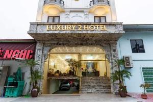 Ðại DínhTỪ SƠN LUXURY 2 HOTEL的大楼前的商店,上面有读豪华酒店的标志