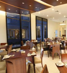 庞卡兰布翁BRITS HOTEL PANGKALAN BUN的餐厅设有木桌、椅子和窗户。