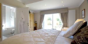 卡纳芬泰罗斯乡村别墅酒店的卧室设有一张白色大床和一扇窗户。
