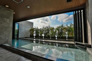 恩纳Hiyori Ocean Resort Okinawa的一座带大窗户的房屋内的游泳池