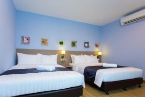 新山DK Hotel的蓝色墙壁客房的两张床