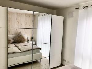腓特烈港Seestern Apartment的卧室配有带镜子的衣柜和1张床